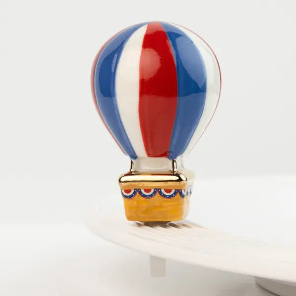 Nora Fleming Mini hot air balloon with red, white, and blue colors on a white background. Available at Be Charmed