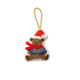 A small Rifle Paper Co embroidered Christmas ornament shaped like a teddy bear wearing a red Santa hat and a red patterned sweater, hanging from a tan string on a white background. Available at Be Charmed