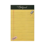 A yellow lined notepad with a dark green header band reading 'Notepad' and a small pink 'Eraser' tab, shown on a light gray background. Available at Be Charmed