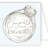 Card with an illustration of a diamond ring and 'Congrats, you're engaged' text on a light blue background. Available at Be Charmed