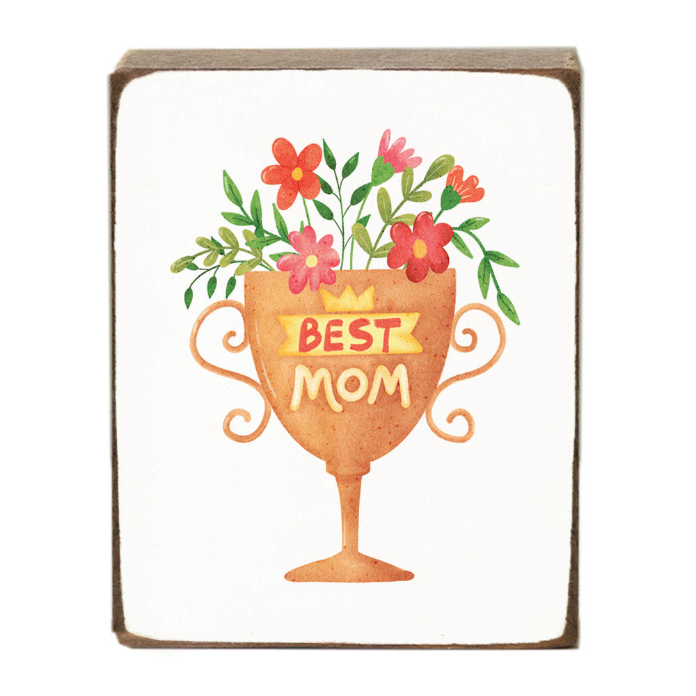 Decorative block with a cup of flowers and 'Best Mom' text on a white background. Available at Be Charmed