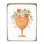 Decorative block with a cup of flowers and 'Best Mom' text on a white background. Available at Be Charmed