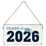 Decorative sign with 'Class of 2026' text and a graduation cap icon on a white background. Available at Be Charmed