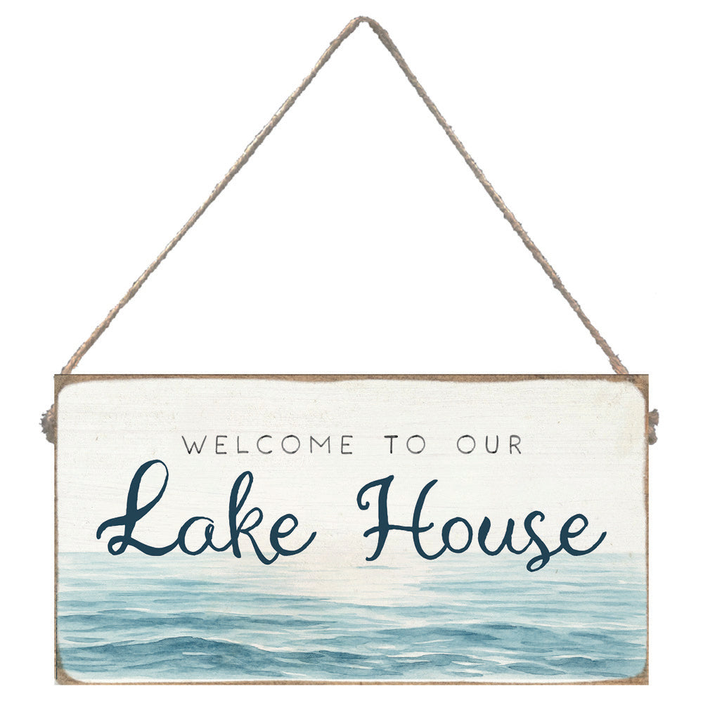 Decorative sign with 'Welcome to our Lake House' text and water design. Available at Be Charmed