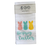 A rustic style tea towel with 'Happy Easter' text and decorative bunny illustrations in multicolor on a white background. Available at Be Charmed