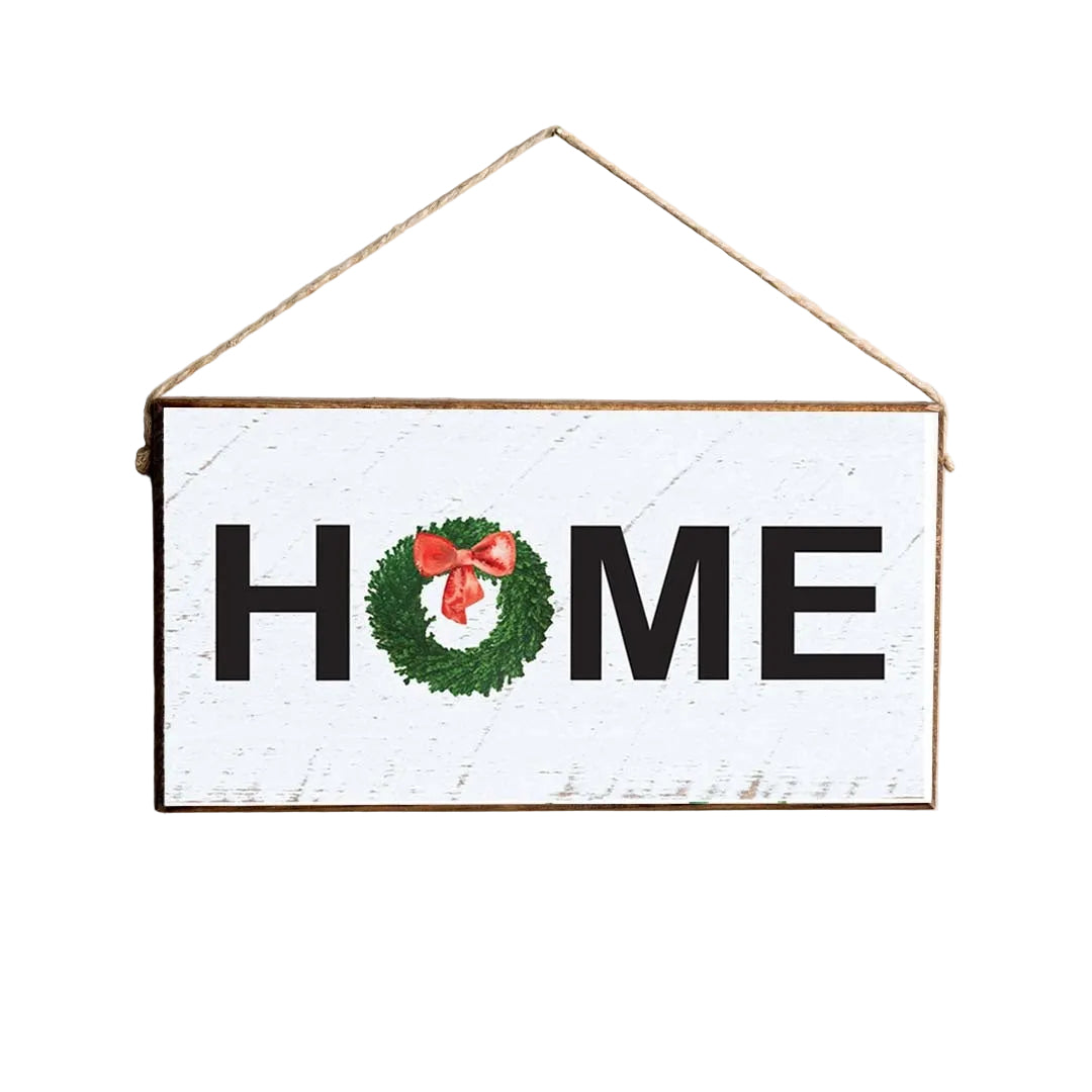 A rustic marlin style twine sign with the word 'Home' written in large black letters, decorated with a green watercolor wreath and a red bow. Available at Be Charmed