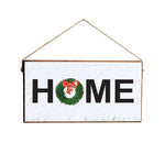 A rustic marlin style twine sign with the word 'Home' written in large black letters, decorated with a green watercolor wreath and a red bow. Available at Be Charmed