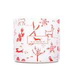A white candle with red animal patterns including a deer and a dog, and the brand 'Scout' visible on the lid. Available at Be Charmed