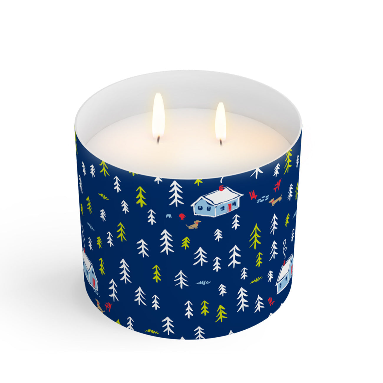 A clear Scout candle with a blue label featuring a Christmas cabin and tree pattern, with a lit wick. Available at Be Charmed