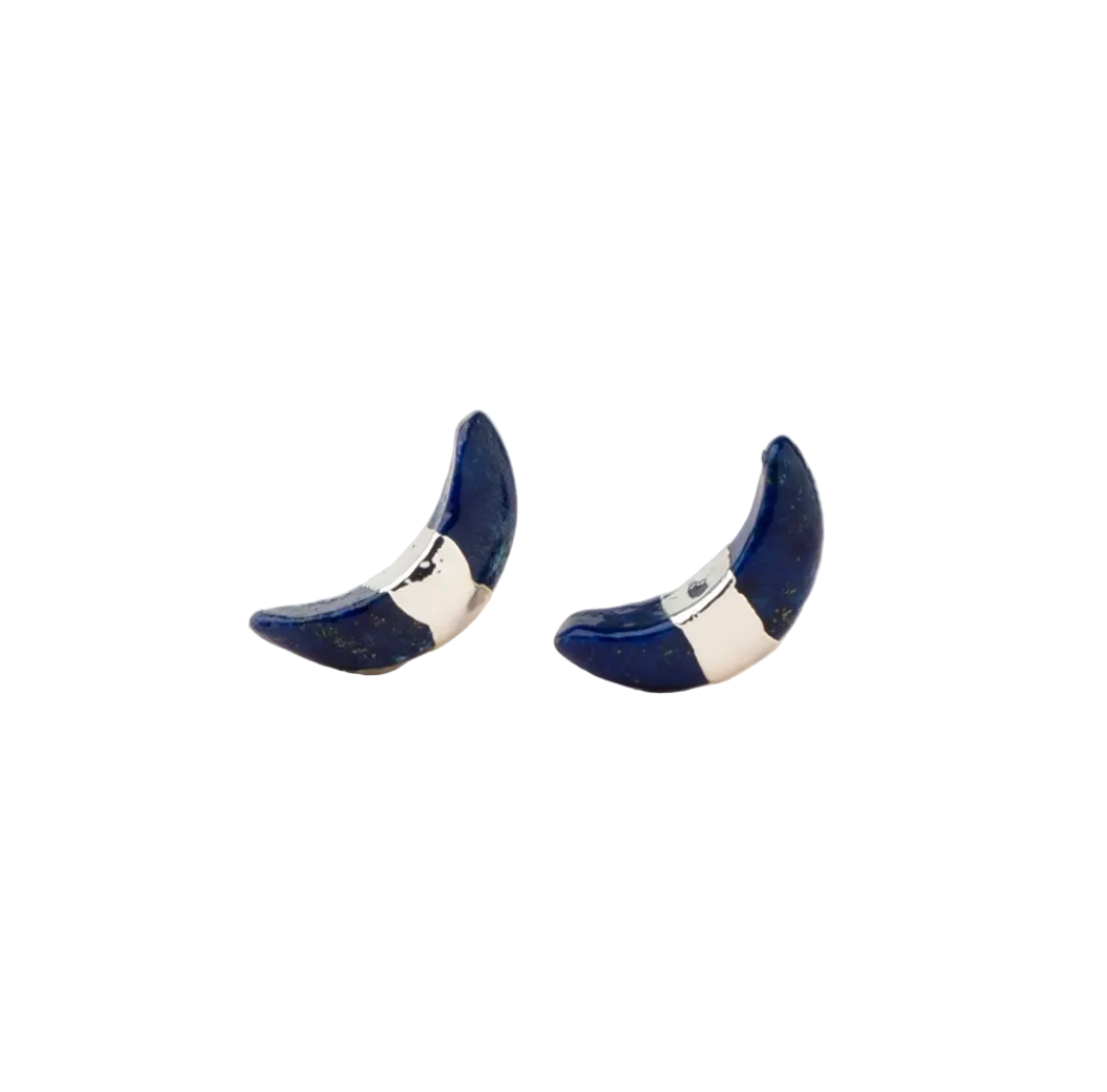 Pair of crescent moon stud earrings on a white background. Available at Be Charmed