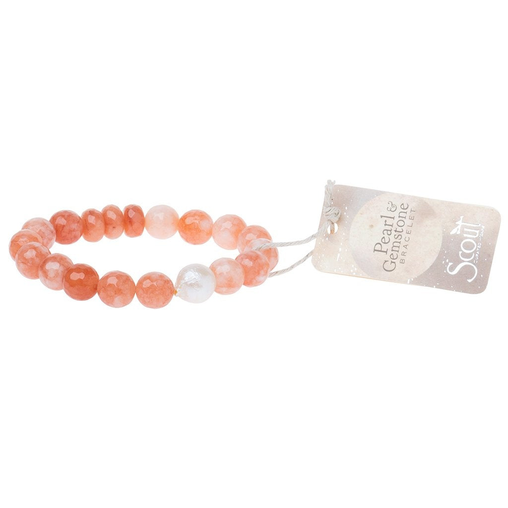 A bracelet with a series of faceted gemstone beads and a single freshwater pearl, presented on a stretch cord with a branded hangtag. Available at Be Charmed