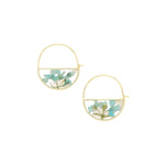 Gold hoop earrings with floral design on a beige background