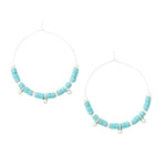 A pair of hoop earrings with blue stone discs and silver accents, arranged in a hoop shape. Available at Be Charmed