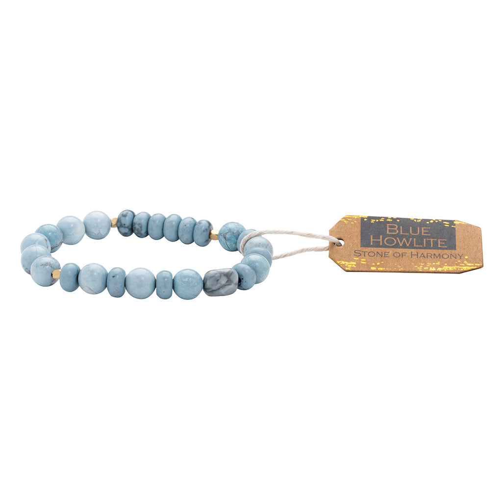 A blue stone stacking bracelet with a label tagged 'SCOUT HOWLITE stone of harmony'. Available at Be Charmed