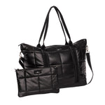 A Scout black quilted puffer tote bag with dual top handles and a detachable shoulder strap, shown alongside a matching small zip pouch on a white  background. Available at Be Charmed