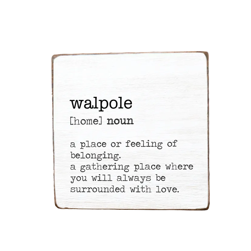 A decorative wooden block with the text 'WALPOLE a place or feeling of belonging, a gathering place where you will always be surrounded by love.' on it, with a definition of 'Homeless' written at the top. Available at Be Charmed