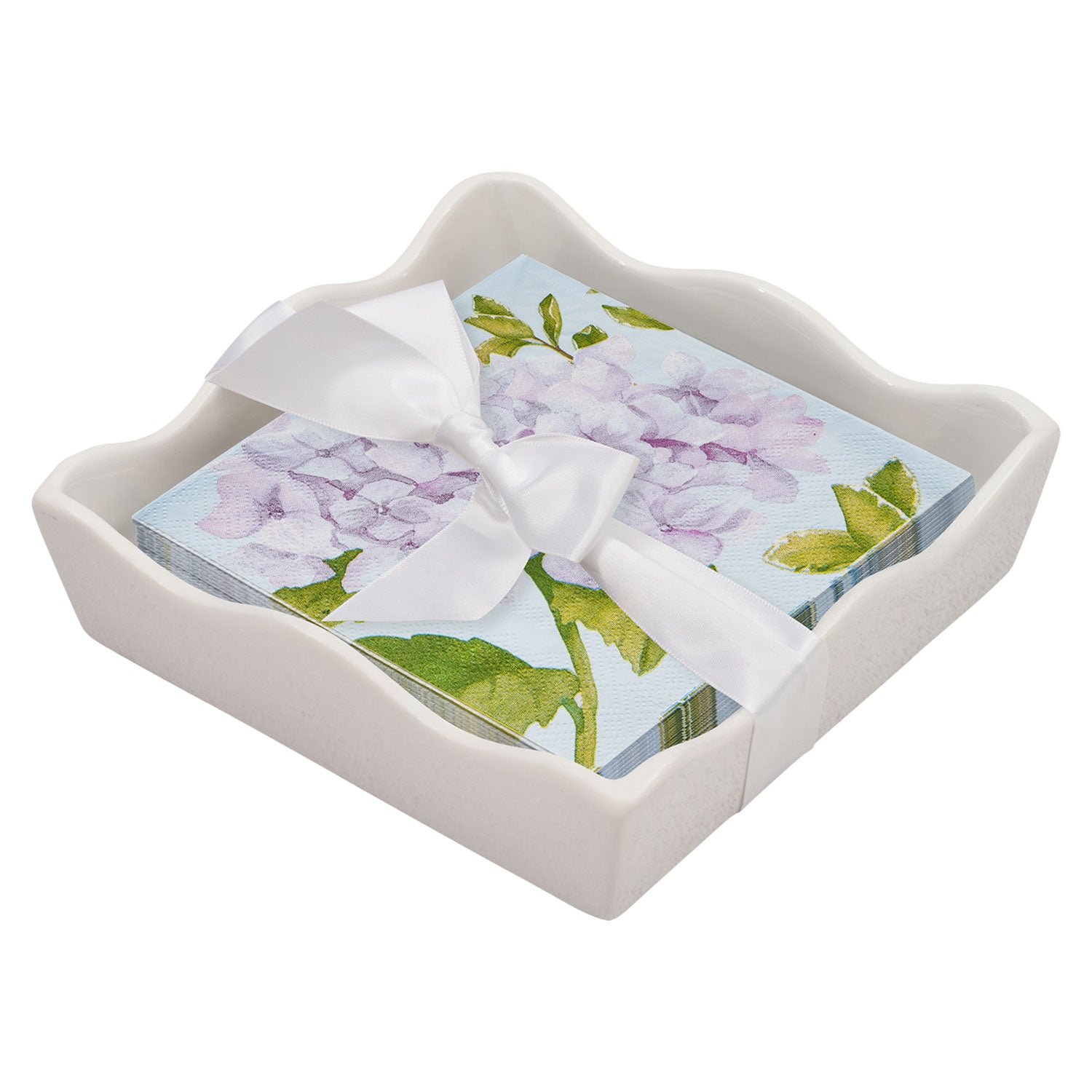 Floral napkins with a white ribbon in a decorative white holder on a white background. Available at Be Charmed