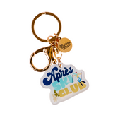 The Darling Effect keychain with 'Apres Ski Club' tag and gold ring on a white background. Available at Be Charmed. 