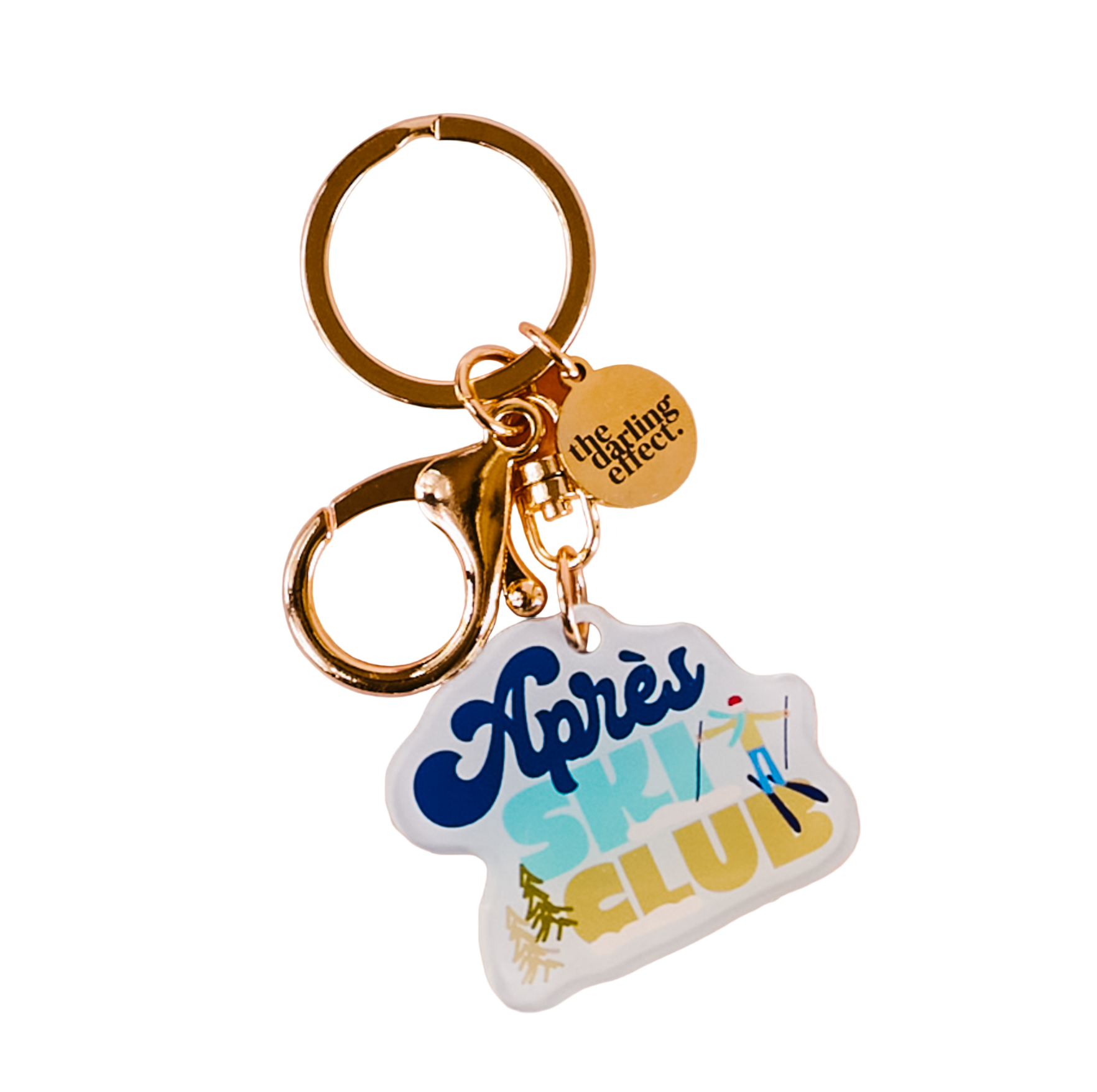 The Darling Effect keychain with 'Apres Ski Club' tag and gold ring on a white background. Available at Be Charmed. 