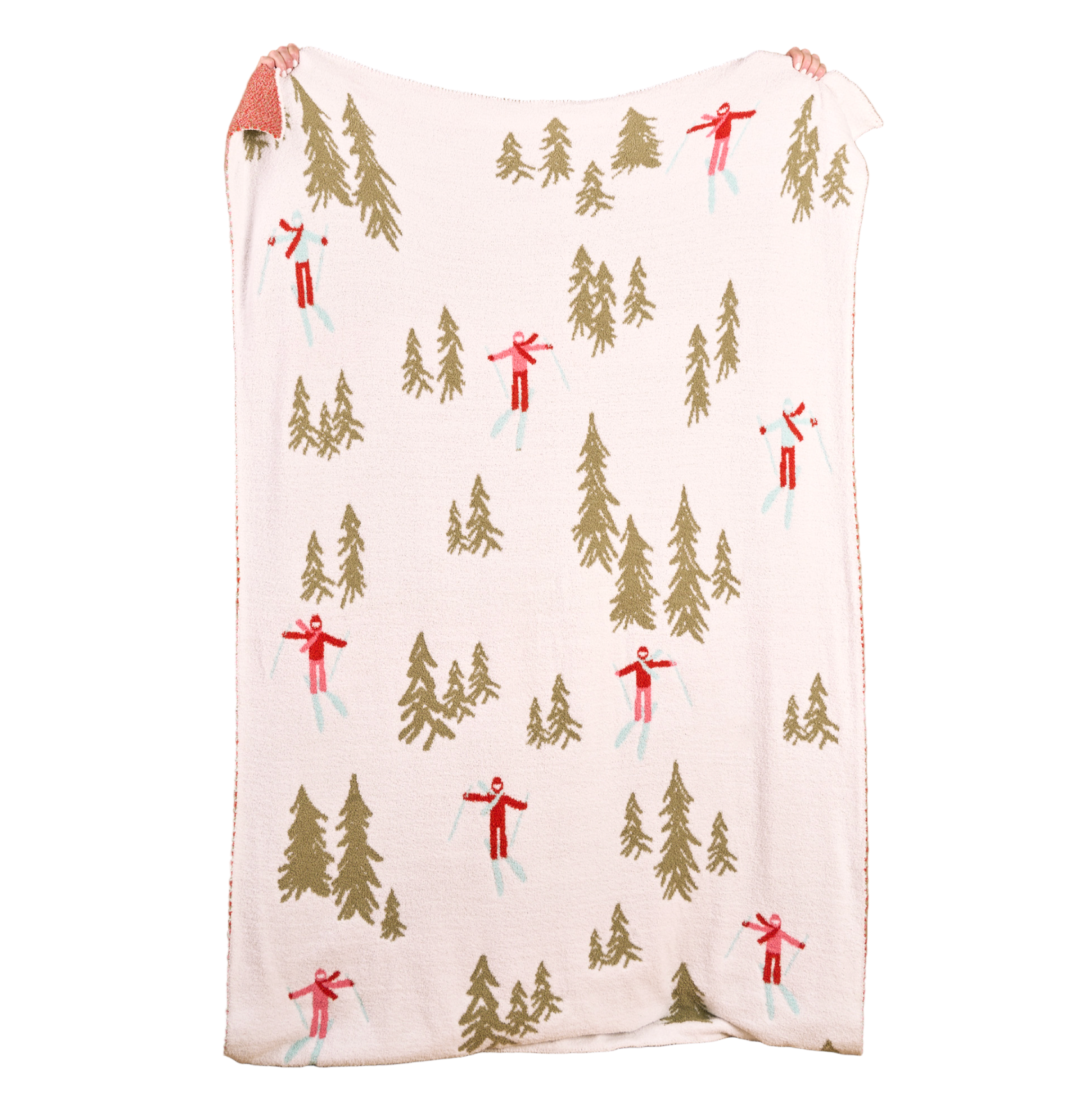 The Darling Effect throw blanket with winter scene pattern featuring trees and skiers on a white background. Available at Be Charmed. 