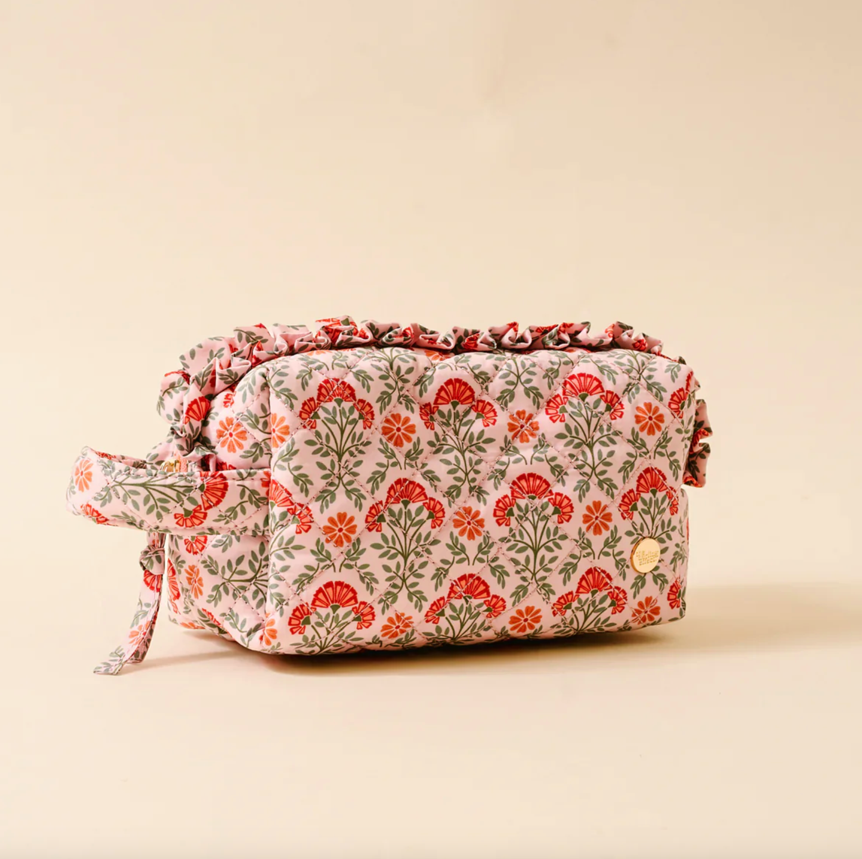Floral patterned toiletry bag on a beige background. Available at Be Charmed