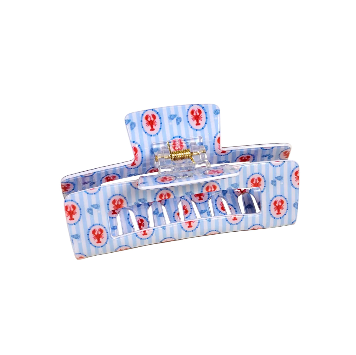 Blue hair clip with red lobster pattern on a beige background. Available at Be Charmed