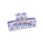 Blue hair clip with red lobster pattern on a beige background. Available at Be Charmed