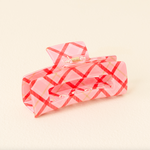 The darling effect pink checkered hair claw clip on a beige background. Available at Be charmed.