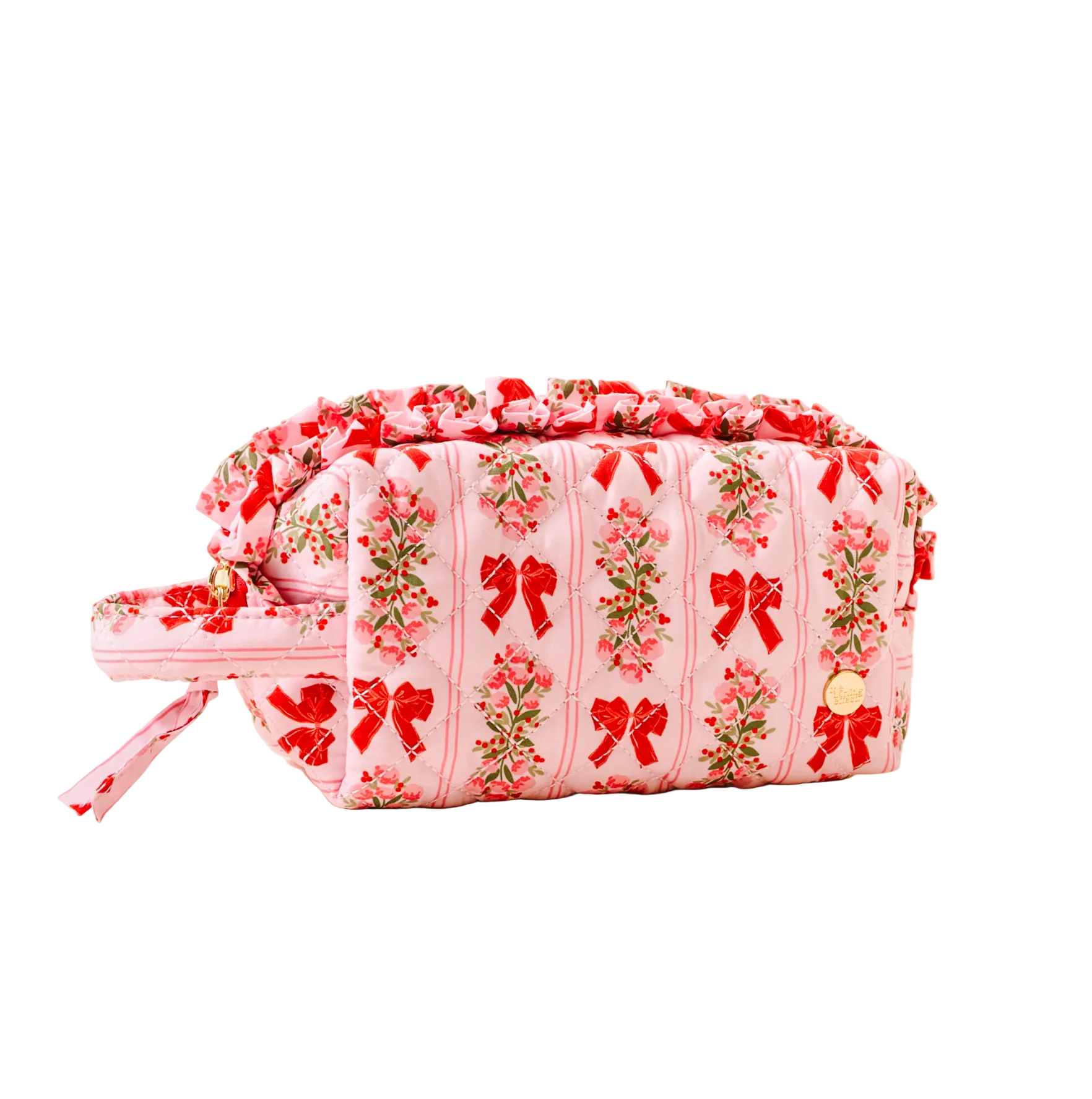 Pink cosmetic bag with floral and bow pattern on a beige background. Available at Be Charmed. 