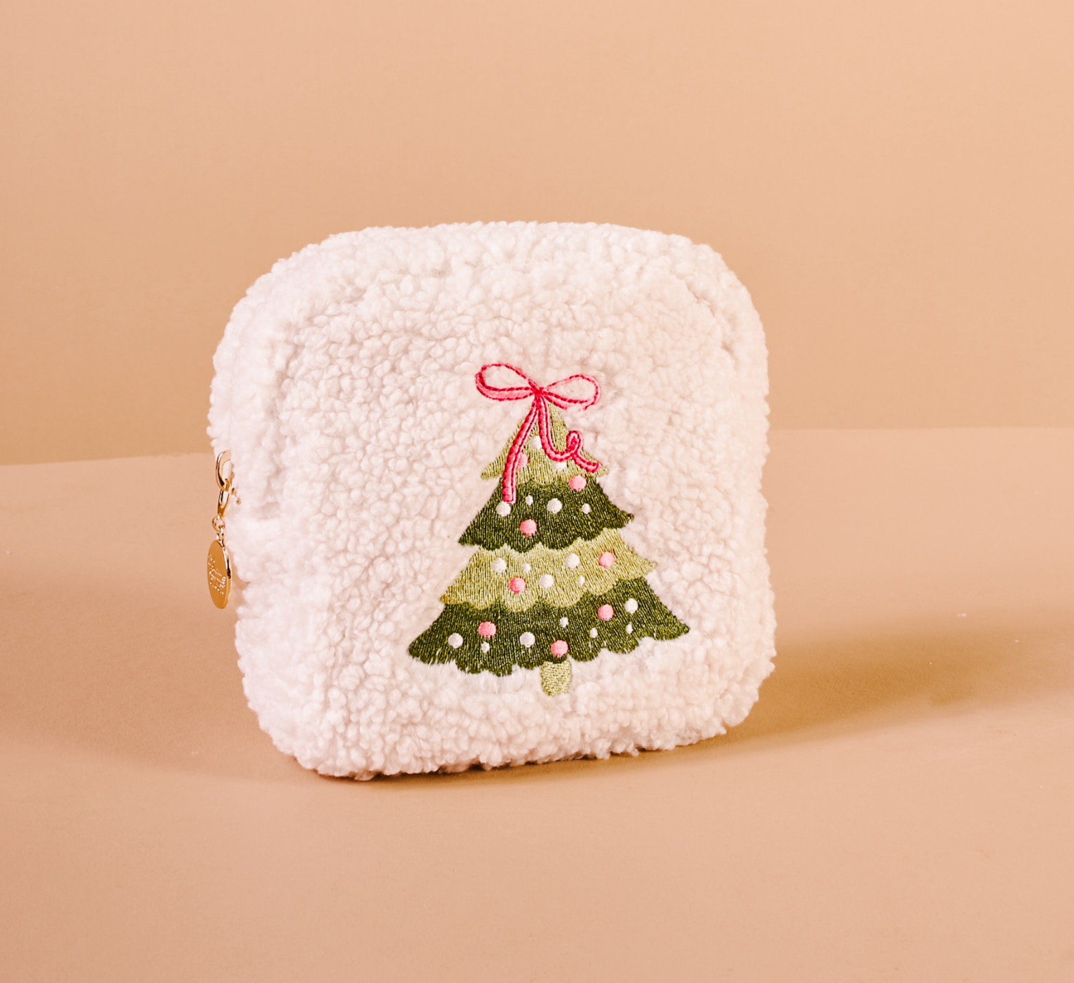 White textured cosmetic pouch with a Christmas tree design on a beige background. Available at Be Charmed.