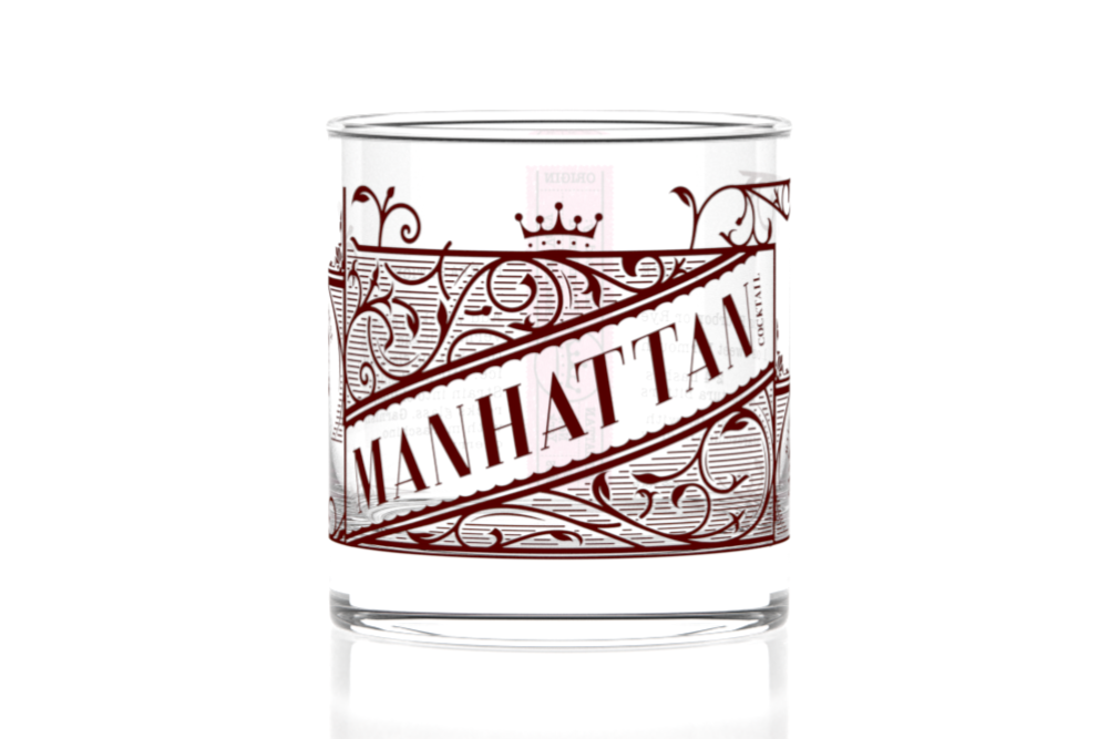 Clear glass tumbler with red 'Manhattan' design on a white background. Available at Be Charme