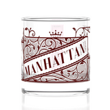 Clear glass tumbler with red 'Manhattan' design on a white background. Available at Be Charme