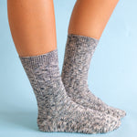 Gray marbled world softest cable crew socks worn by a person on a light blue background. available at Be charmed